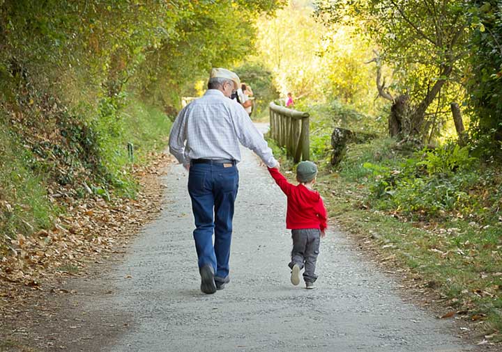 man and child walking while holding hands